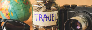 Money jar labelled travel that is filled with coins