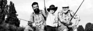 Three men of different ages cast their lines while sitting on a dock